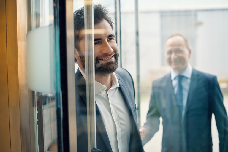 Ein Mann in Anzug schaut durch eine Scheibe