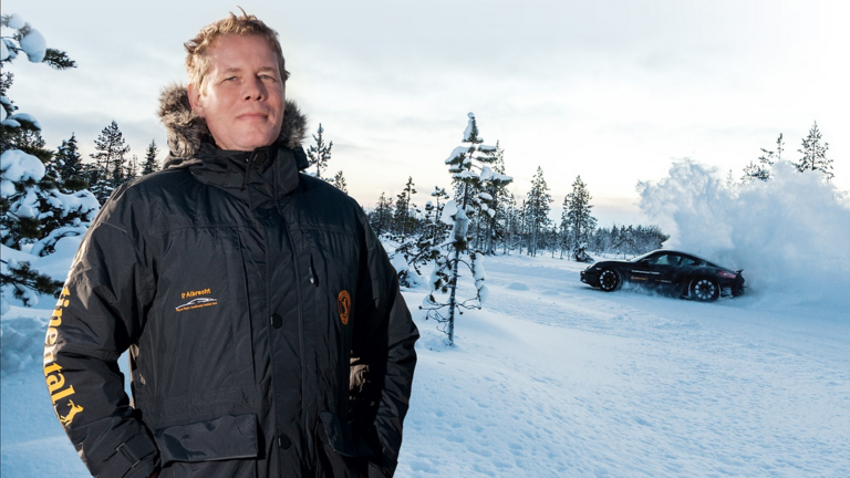 A man in a winter coat is standing on a highway bridge