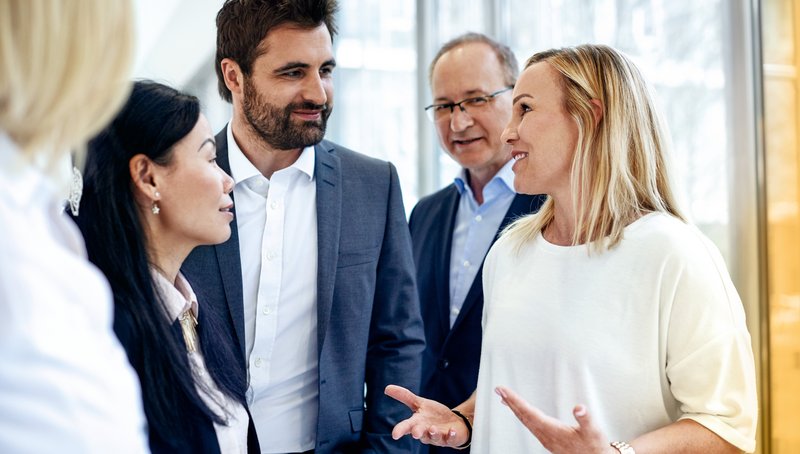 A group of five people are discussing together