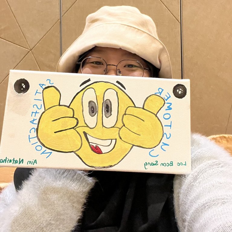 A lady holding a painting she drew herself