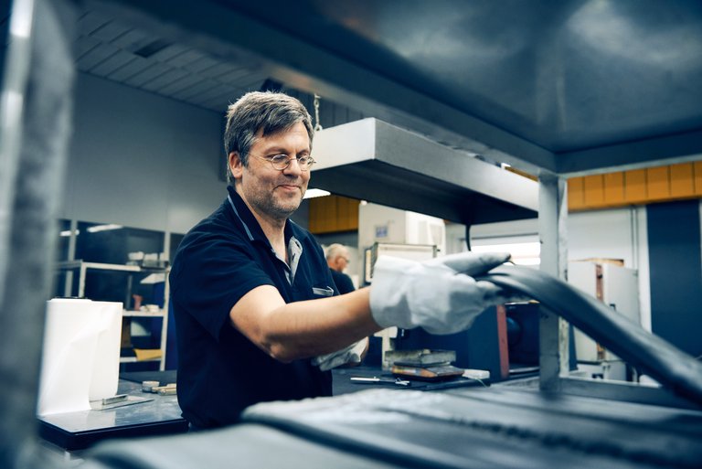 A man handles a rubber in a production hall