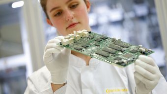 A Continental employee performing a visual inspection on a body control unit.