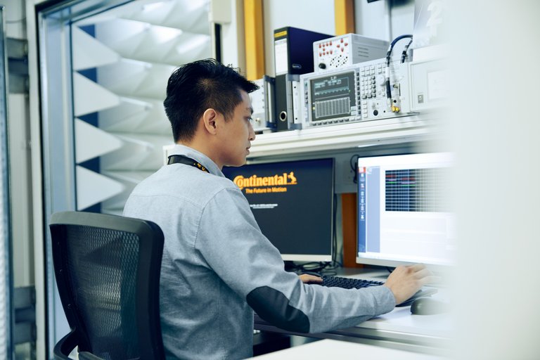 Ein Mann sitzt vor zwei Computerbildschirmen